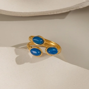Gros plan détaillé d'une bague dorée ajustable ornée de trois pierres lapis-lazuli