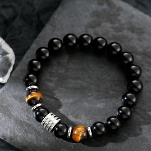 10mm Tiger Eye and Obsidian beaded bracelet for men on a natural dark rock background