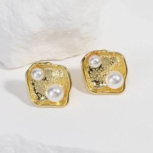 Detailed view of 18k gold plated hammered square earrings with inlaid white pearls