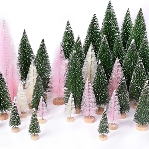 Close-up of mini bottle brush Christmas trees in green, pink and white with wooden bases