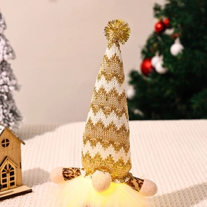 Detail of LED glowing Christmas gnome with golden sequined hat in a warm festive setting