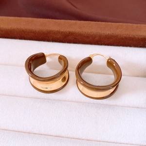Detailed close-up of 18k gold plated C-shaped hoop earrings with brown enamel finish
