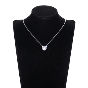 Detail of silver cat-ear pearl necklace displayed on a professional black bust model
