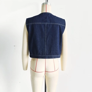 Detail view of dark blue denim vest back with white contrast stitching and vertical seams