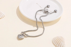 Detail of silver heart charm bracelet with adjustable slider clasp and sparkling stones