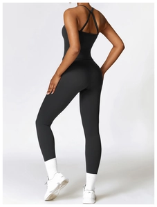 Detail of high-waist black yoga pants and cross-back sports top showing shaping effect