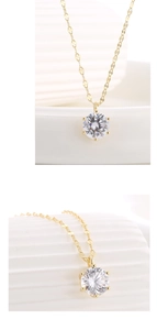 Macro detail of a classic gold S925 silver necklace featuring a six-prong zircon pendant