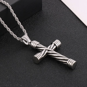 Polished stainless steel cross pendant necklace with twisted rope chain on black texture