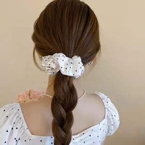 Polka dot oversized scrunchie in white satin finish worn on a high ponytail style
