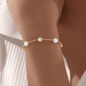 Elegant gold stainless steel bracelet with white pearls and a central round zircon stone