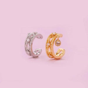 Detailed view of silver and gold non-pierced ear cuffs with sparkling cubic zirconia stones