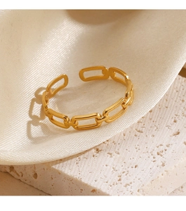 Detail of adjustable gold-plated chain link ring on stone and silk background