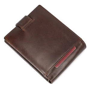 Detail of dark brown leather wallet showing snap button strap and stitching texture