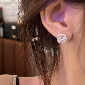 Close-up of a silver square stud earring with sparkling cubic zirconia on model