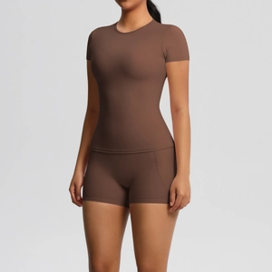 Detail of high-stretch seamless yoga set in dark brown featuring short sleeves and shorts