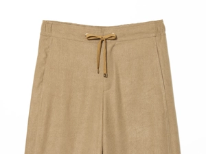 Detail of khaki corduroy pants showing elastic waist, drawstring with gold metal tips