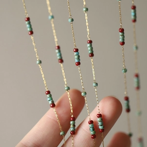 Vintage style necklace with red and turquoise beads on a thin gold chain