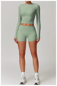 Détail d'un haut court à manches longues vert sauge et d'un short de fitness taille haute