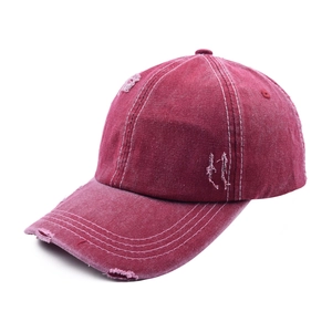Close-up of distressed burgundy washed denim baseball cap with vintage frayed holes