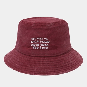 Detail of burgundy washed cotton bucket hat with white text embroidery on vintage fabric