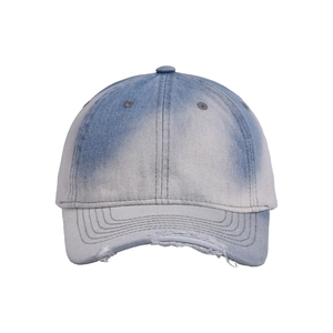 Macro detail of distressed denim cap with frayed edges and washed gradient texture