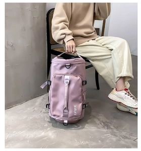 Macro detail of pink cylinder travel bag showing white logo and durable nylon texture