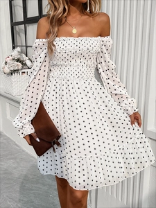 Detail of off-shoulder white polka dot dress with smocked chest and ruffled hemline