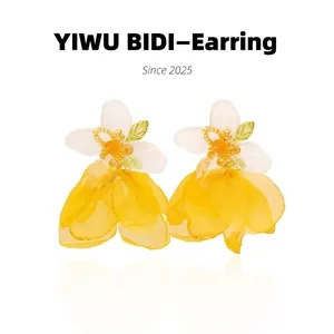 Detail of floral drop earrings with white petals and yellow tulle fringe design