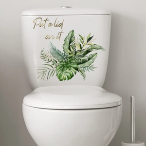 Detail of green tropical leaves wall decal with Put a lid on it text for bathroom decor