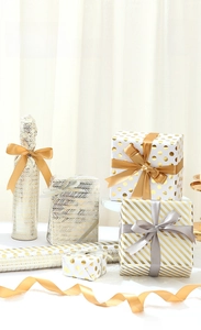 Detail showing gift boxes wrapped in gold foil patterned paper with elegant ribbons