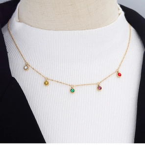Detail of 18K gold plated necklace with five colorful round zircon pendants on a model