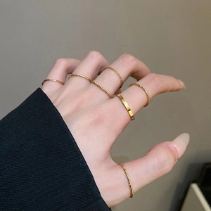Close-up of minimalist gold plated stacking rings set showing smooth and twisted textures