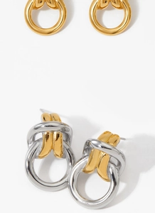 Detailed view of intertwined gold and silver hoop earrings with polished finish