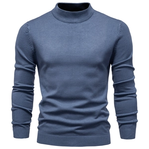 Detailed view of indigo blue turtleneck sweater showing fine knit texture and ribbed cuffs
