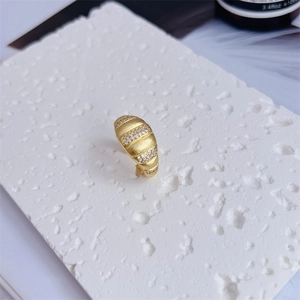 Macro shot of 18K gold plated ring with triple-row cubic zirconia on stone base