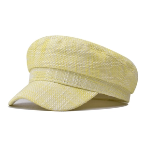 Detailaufnahme der gelb-weißen Tweed-Schirmmütze mit strukturierter Webart und kurzem Schirm