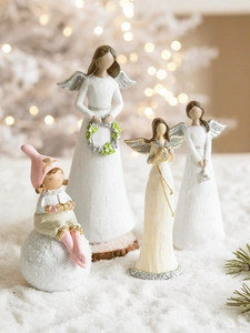 Close-up of resin angel figurines and elf doll for festive Christmas desktop decoration