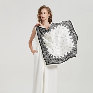 Detail of elegant black and white paisley silk scarf draped over a model's shoulder