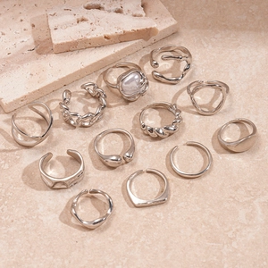 11-piece set of irregular geometric silver rings with pearl detail on stone surface
