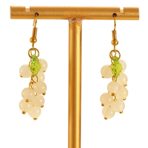 Close-up of elegant grape drop earrings with milky white beads and green leaf charms