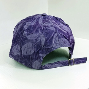 Detail of dark purple textured baseball cap featuring a silver metal adjustable buckle strap