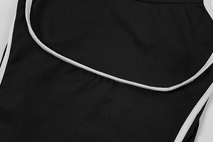 Close-up of black dress fabric featuring high-quality white contrast piping and neat stitching