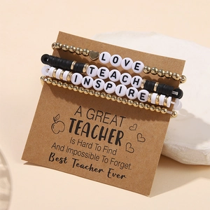 Detail of beaded teacher bracelets set with Love, Teach, Inspire letters on display card