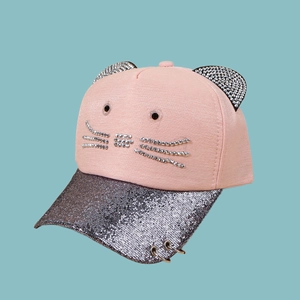 Close-up of pink cat-ear baseball cap with rhinestone whiskers and metal rings on silver brim