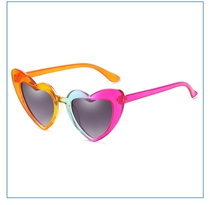 Detail of heart-shaped gradient sunglasses with transparent frame and metal hinges