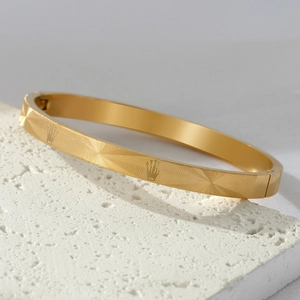 Gold titanium steel bracelet featuring etched crown mesh patterns and hidden clasp