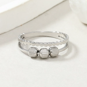 Detailed macro of silver fidget ring with three rotating beads and wave textured band