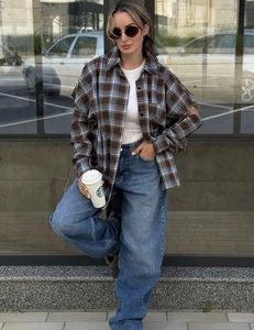 Dettaglio di una camicia a quadri ampia con maniche lunghe e stile street casual urbano