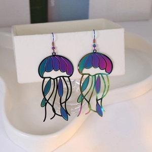Detail of laser iridescent jellyfish earrings with hollow metal tentacles on a display box