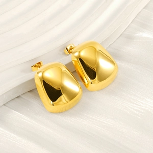 Détail de boucles d'oreilles en acier titane doré poli avec design rectangulaire irrégulier